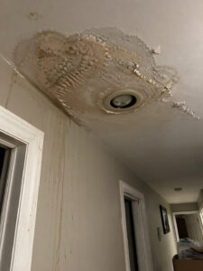 Water damage on hallway ceiling from burst pipe in Layton UT home