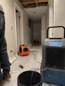 Drying equipment placed in hallway after ceiling water damage in Layton UT