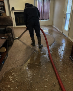 Water extraction in progress in flooded living room during emergency response